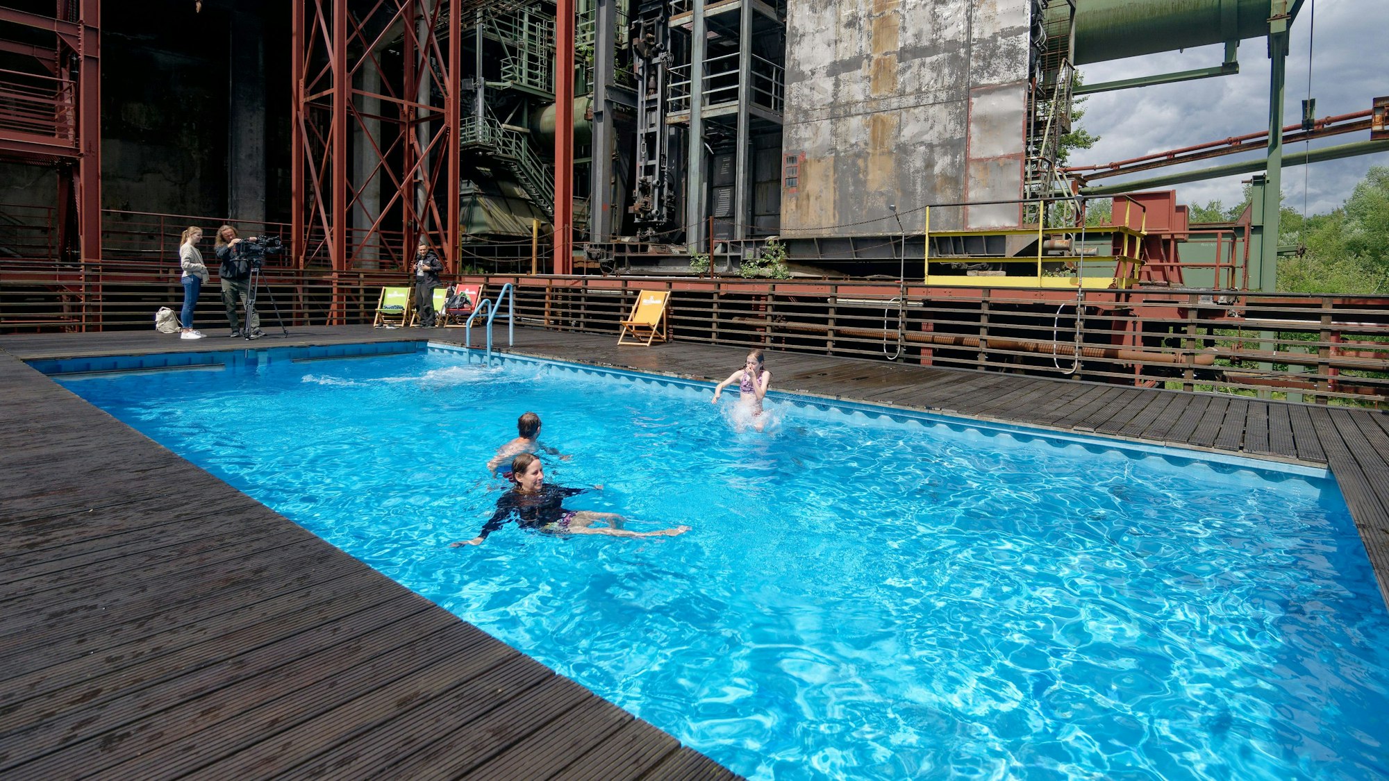 Menschen schwimmen in einem Schwimmbecken, das in der Kokerei einer Zeche errichtet wurde.
