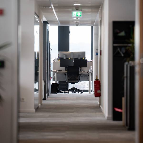 Ein leerer Arbeitsplatz ist am Ende eines Gangs in einem Büro.