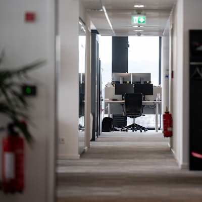 Ein leerer Arbeitsplatz ist am Ende eines Gangs in einem Büro.