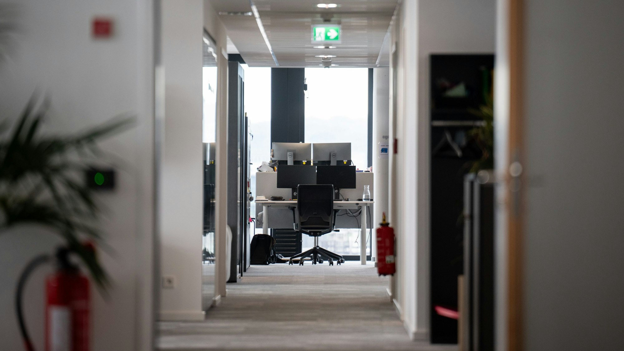 Ein leerer Arbeitsplatz ist am Ende eines Gangs in einem Büro.