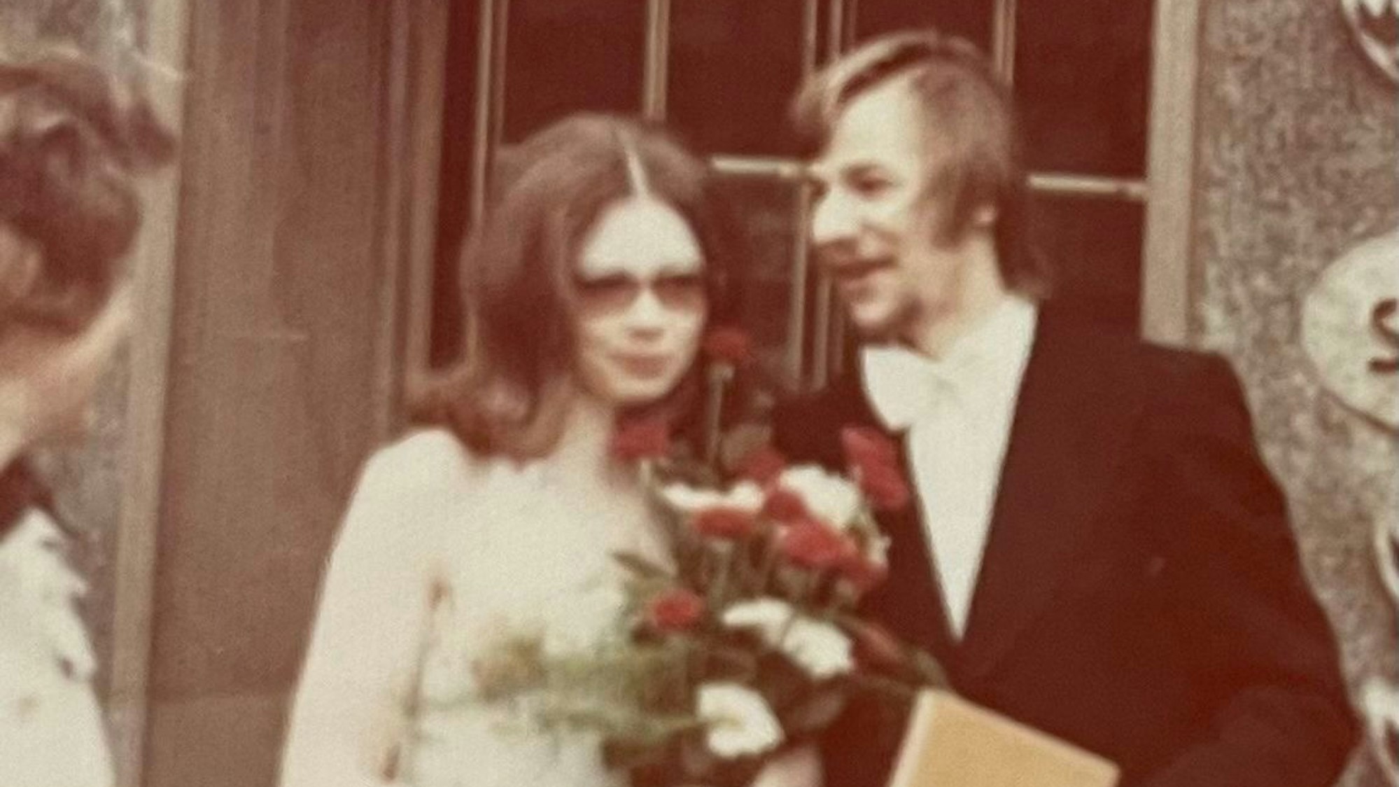 Das junge Paar mit einem bunten Blumenstrauß.