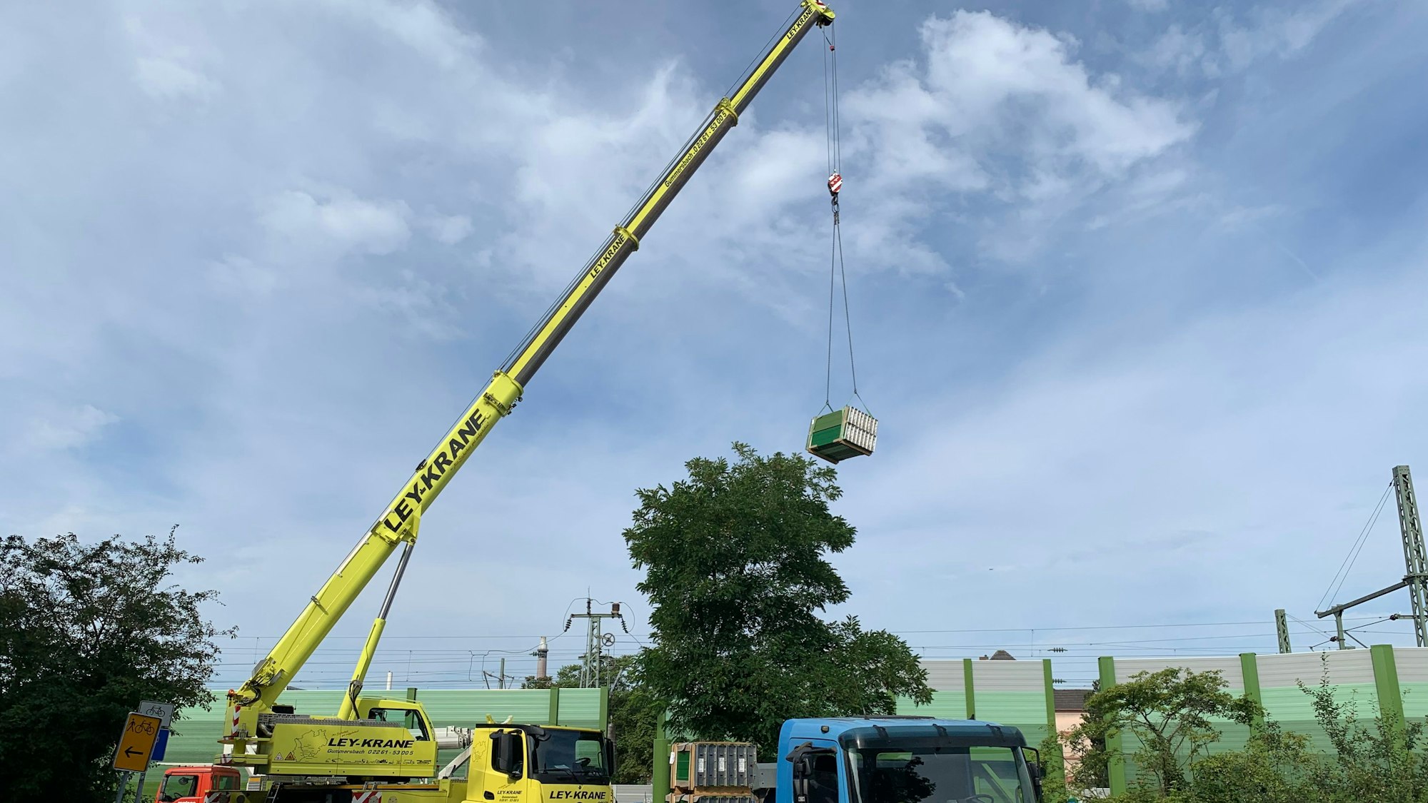 Ein Autokran hebt Material von einem Lkw.