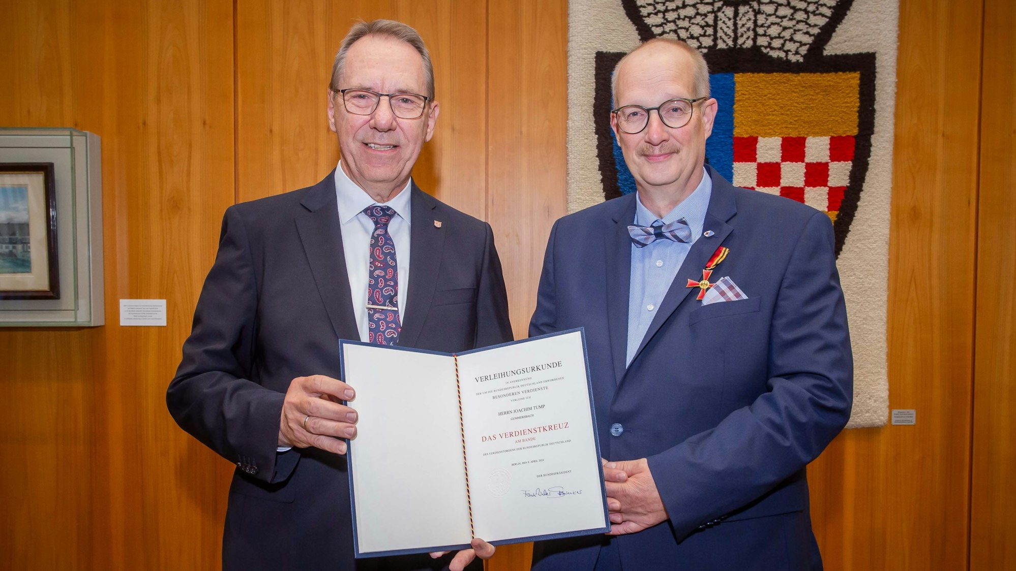 Landrat Jochen Hagt überreicht Joachim Tump die Urkunde.