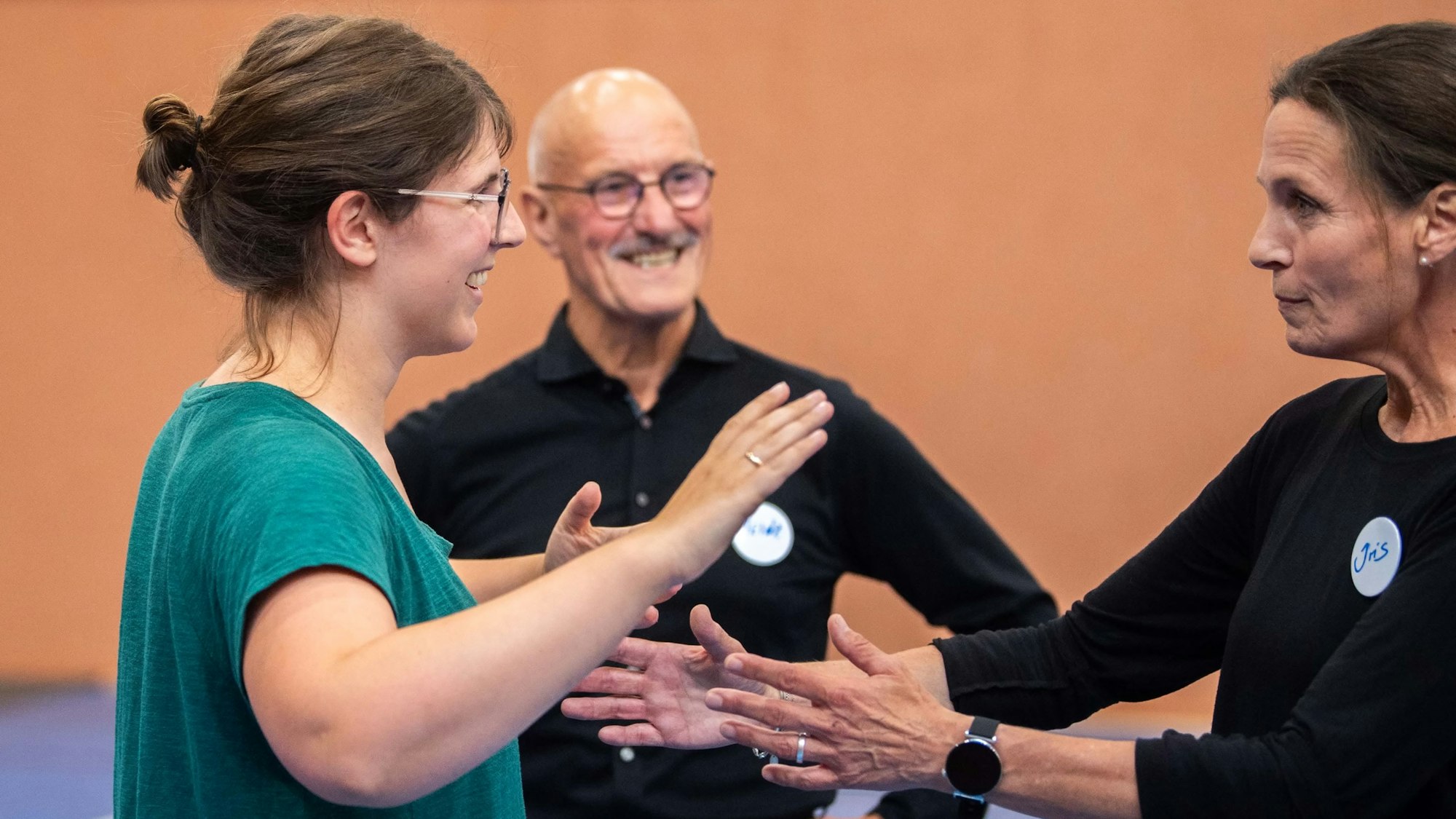 Das Bild zeigt Tanzlehrerin Iris und Tanzexperte Heinrich Schmitz, wie sie Redakteurin Julia Reuß die richtige Haltung erklären.