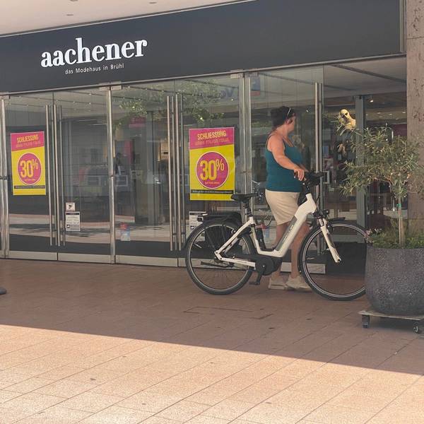 Zu sehen ist der Eingang des Modehauses Aachener in Brühl.