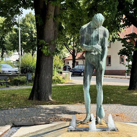 Zu sehen ist ein Brunnen in der Form eines Glasbläsers.