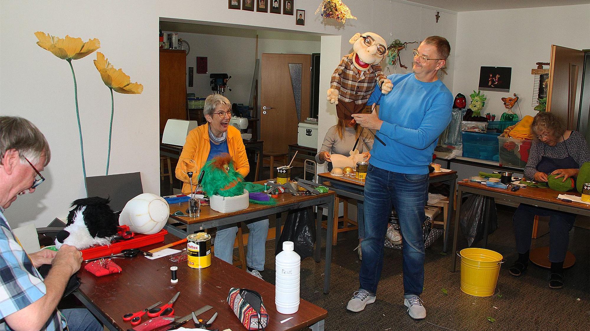 Figurenbildner Norman Schneider (2.v.r.) mit einer Handpuppe und Teilnehmern eines Puppenbaukurses.