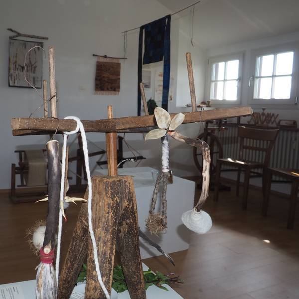Das Bild zeigt einen Ausstellungsraum des Museums, im Vordergrund ein Objekt, das überwiegend aus Holz besteht.