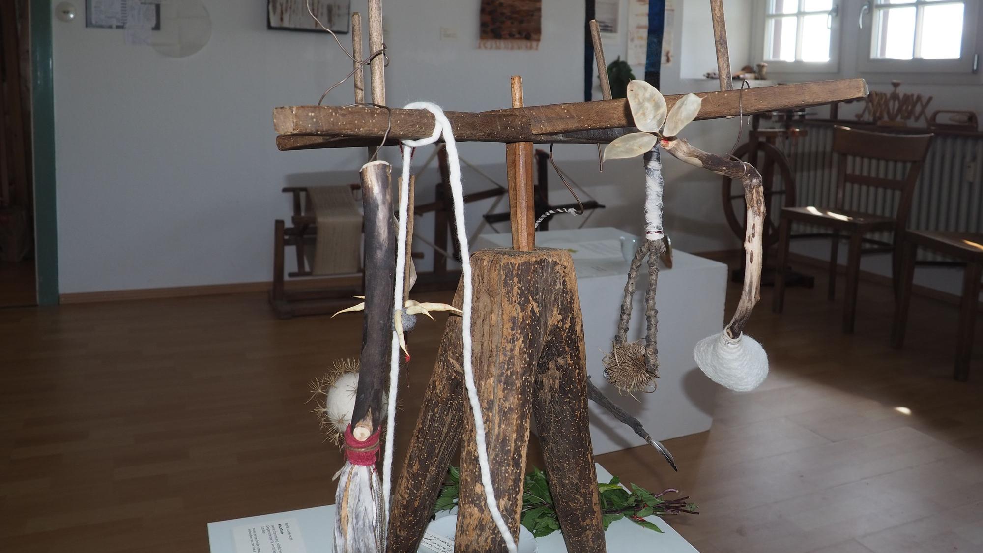 Das Bild zeigt einen Ausstellungsraum des Museums, im Vordergrund ein Objekt, das überwiegend aus Holz besteht.
