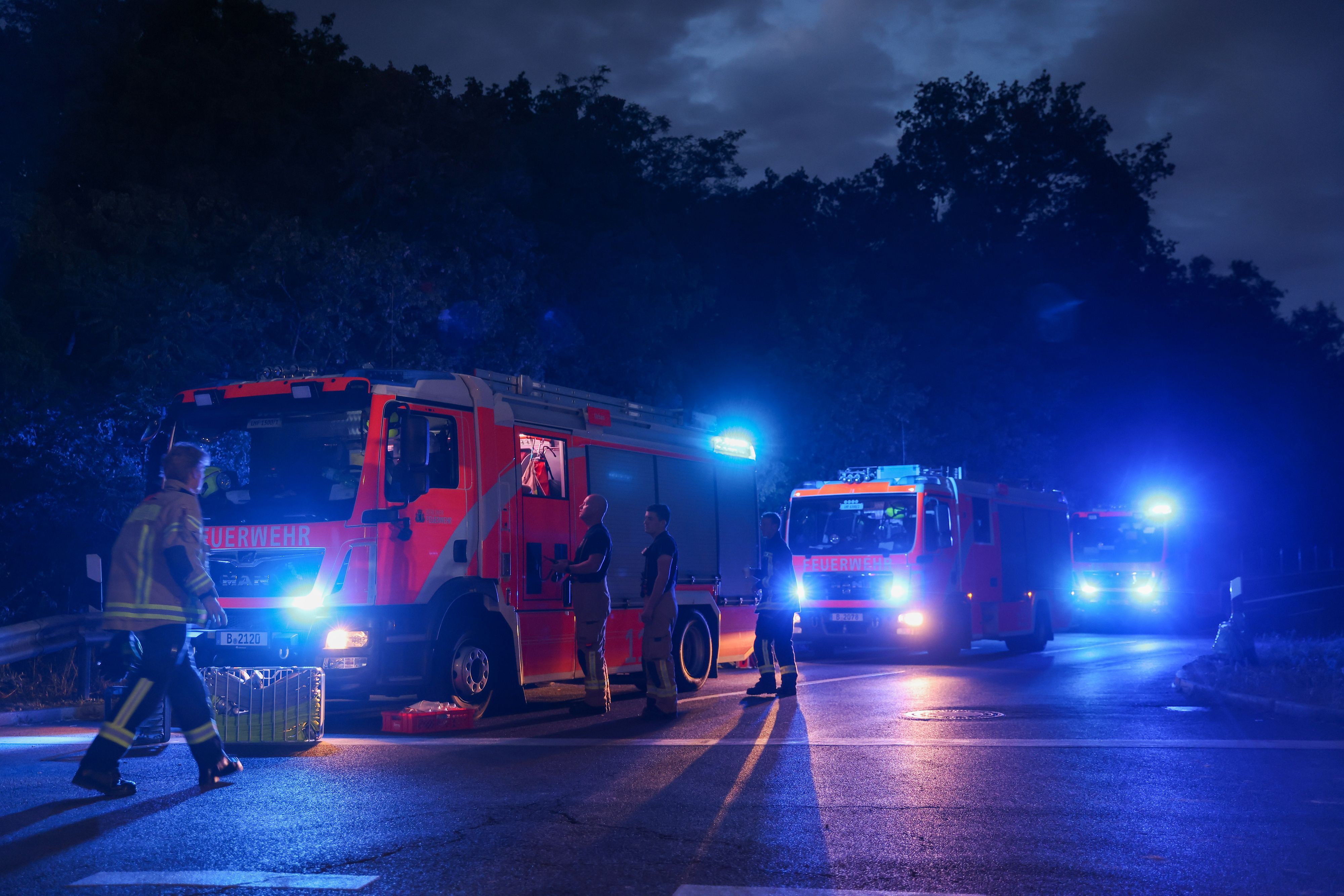 Feuerwahrfahrzeuge stehen mit Blaulicht auf der Abfahrt der Autobahn A115, der Avus, Hüttenweg. Noch immer brennt es auf dem Munitionsplatz im Grunewald. Auf dem Sprengplatz lagert Munition, die Experten dort normalerweise unschädlich machen. +++ dpa-Bildfunk +++