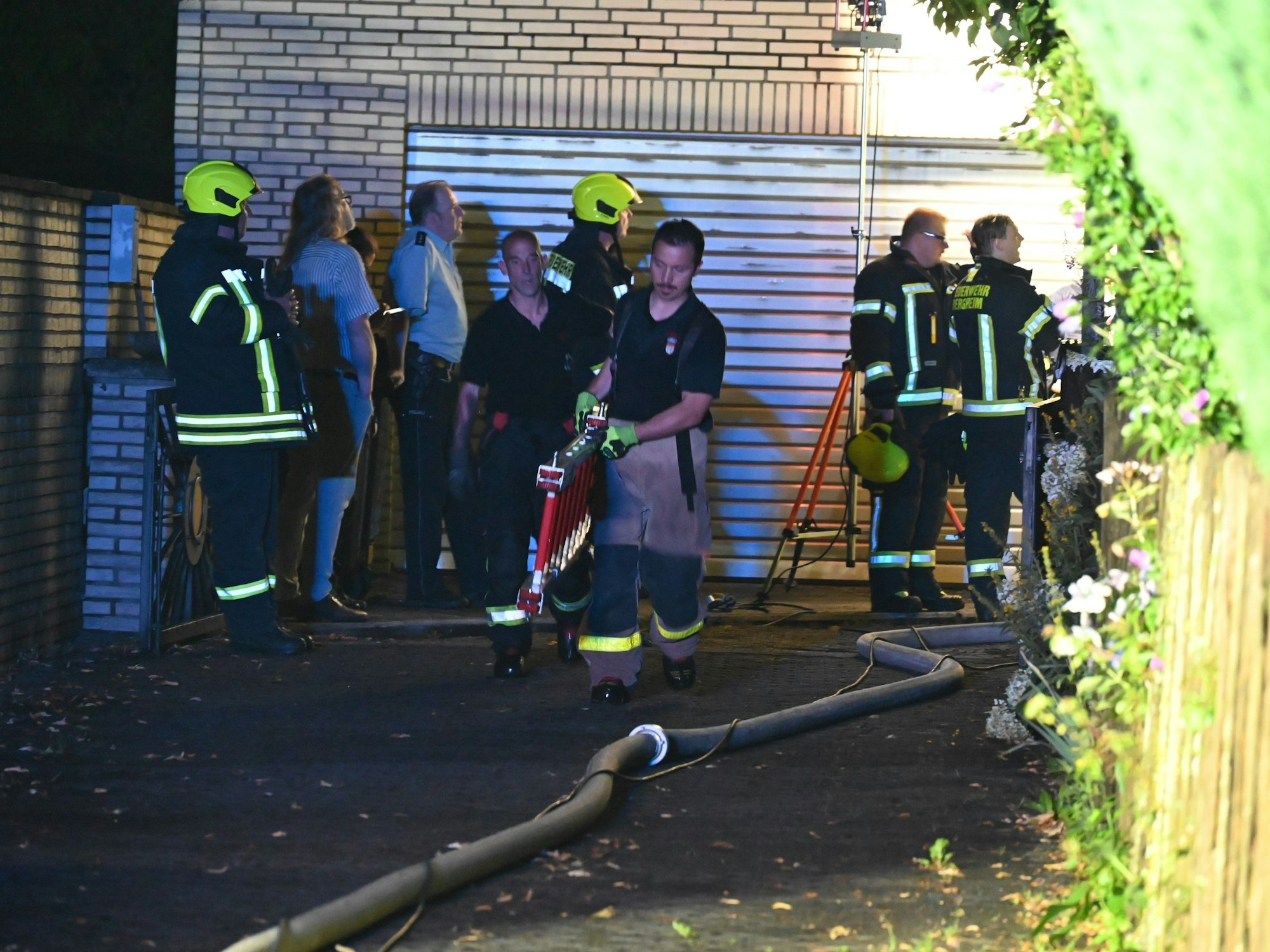 Das Bild zeigt mehrere Einsatzkräfte von Polizei und Feuerwehr am Brandort.