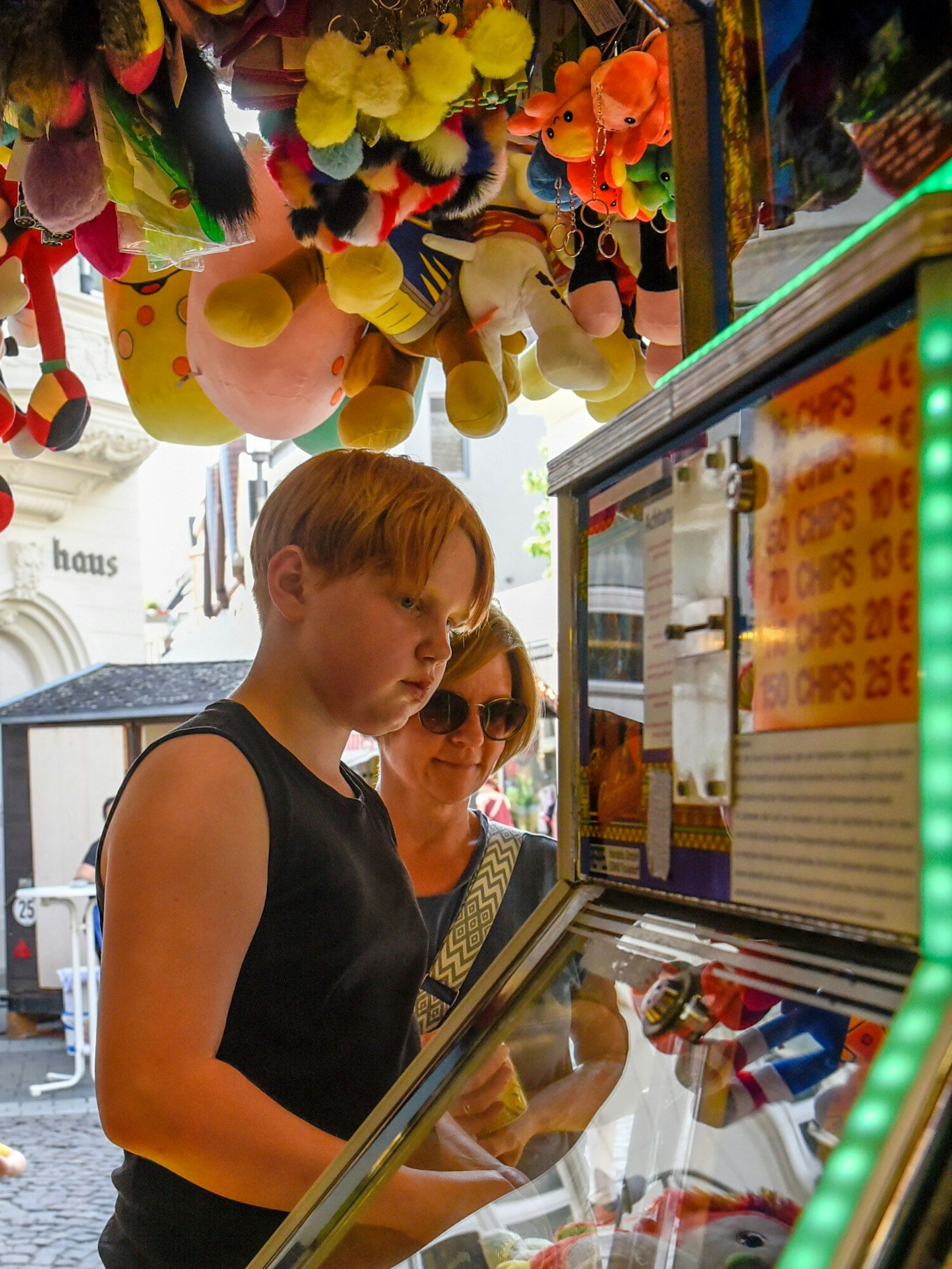 Das Bild zeigt einen Jungen an einem Spielautomaten auf der Kirmes.