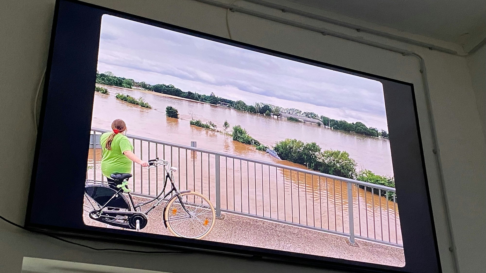 Auf einer Leinwand ist ein Filmausschnitt zu sehen, Wasser, so weit das Auge reicht.
