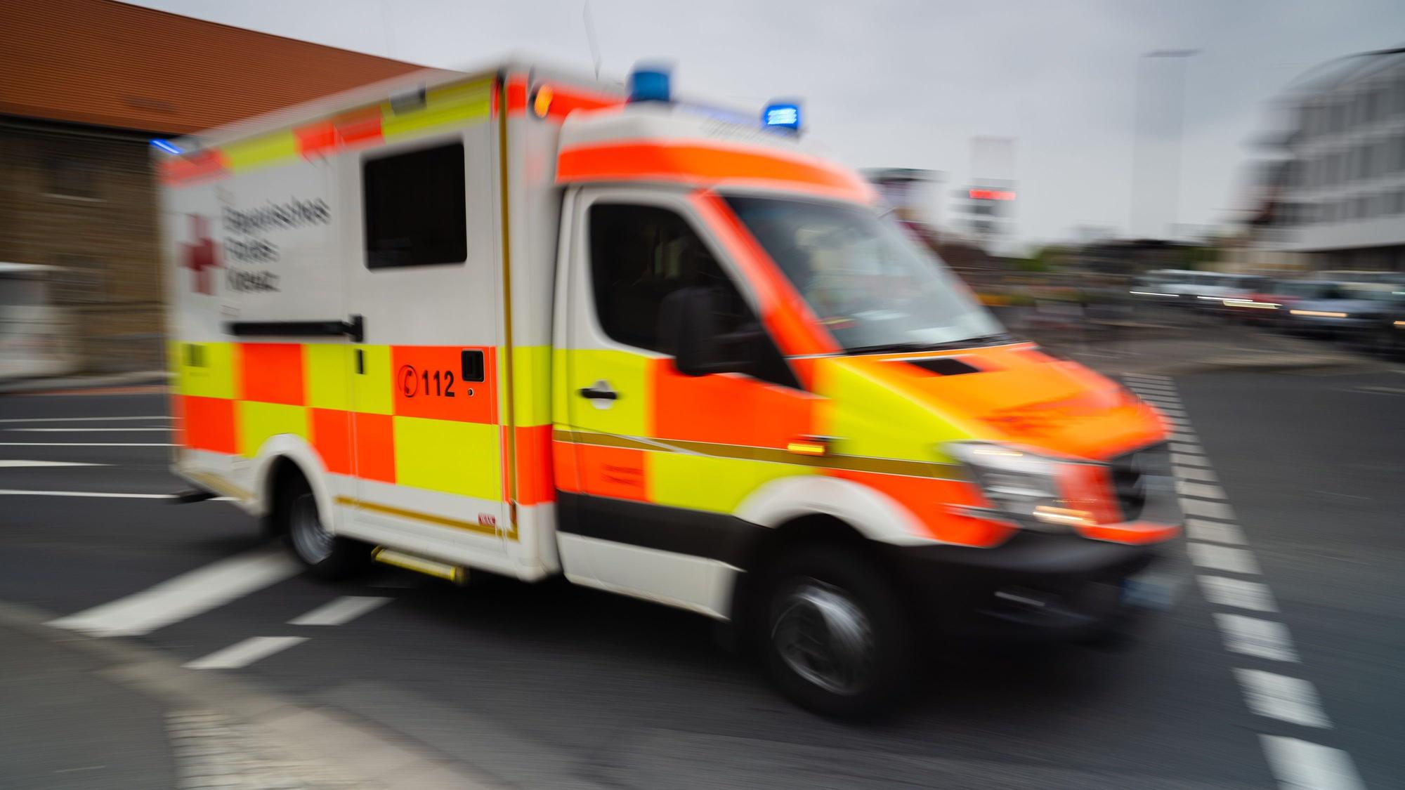 Es ist ein Krankenwagen zu sehen, der auf der Straße fährt.