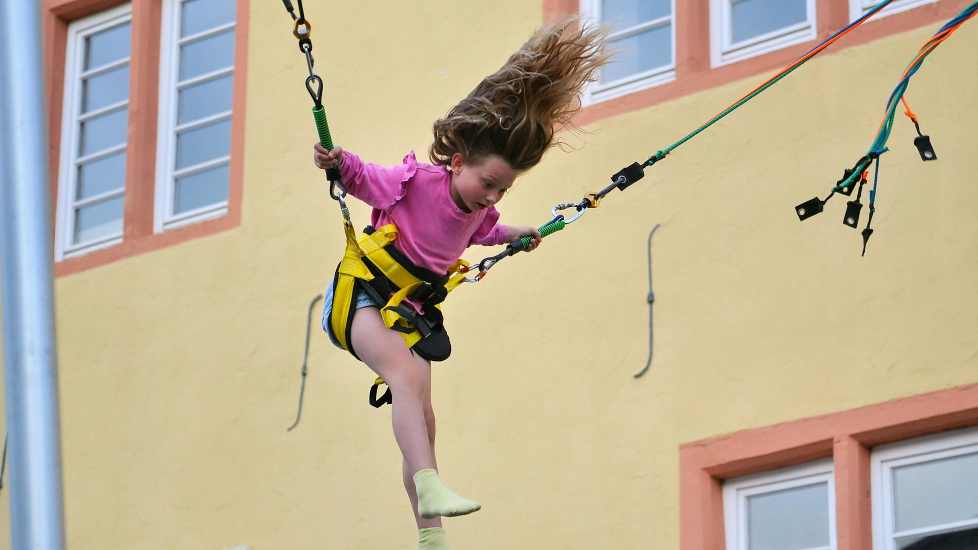 Ein Mädchen wirbelt – gut gesichert – durch die Luft.