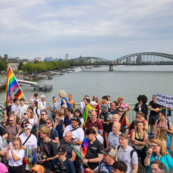 Teilnehmende stehen auf der Brücke und schauen sich die Parade an.
