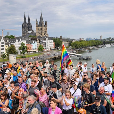 Teilnehmende stehen auf der Brücke und schauen sich die Parade an.