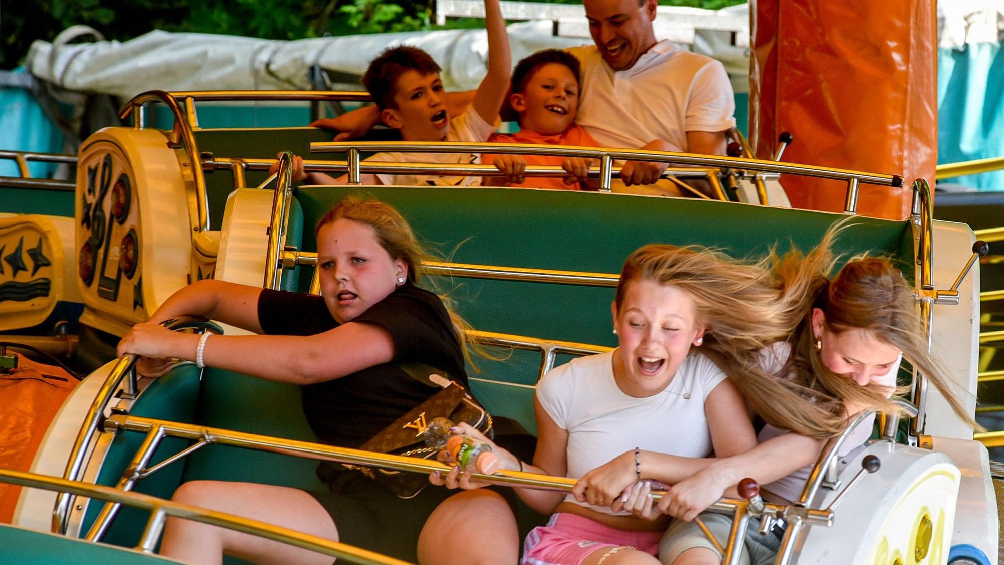 Das Bild zeigt Kinder auf einem Fahrgeschäft.