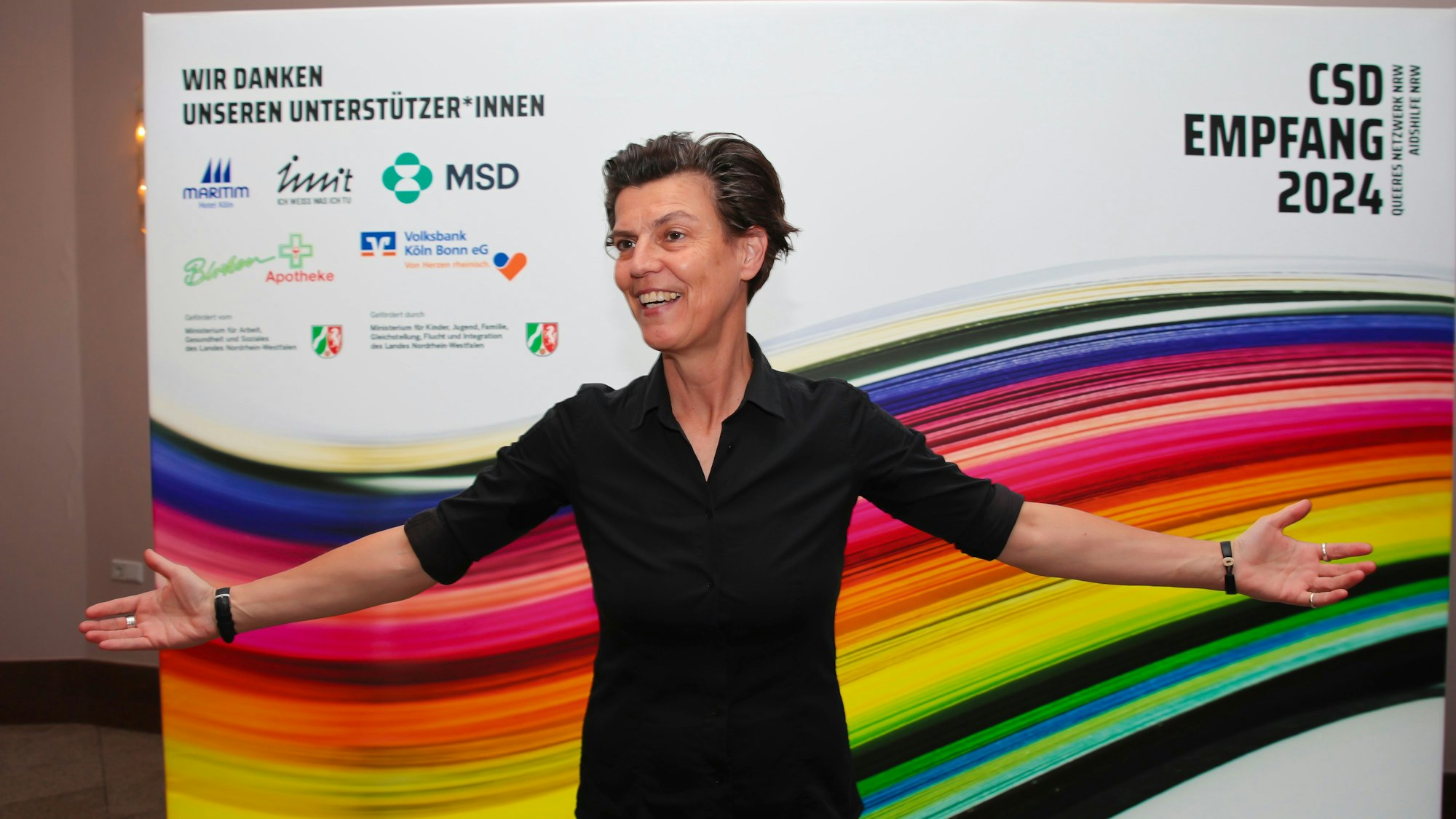 Carolin Emcke steht mit ausgebreiteten Armen vor der Kamera.