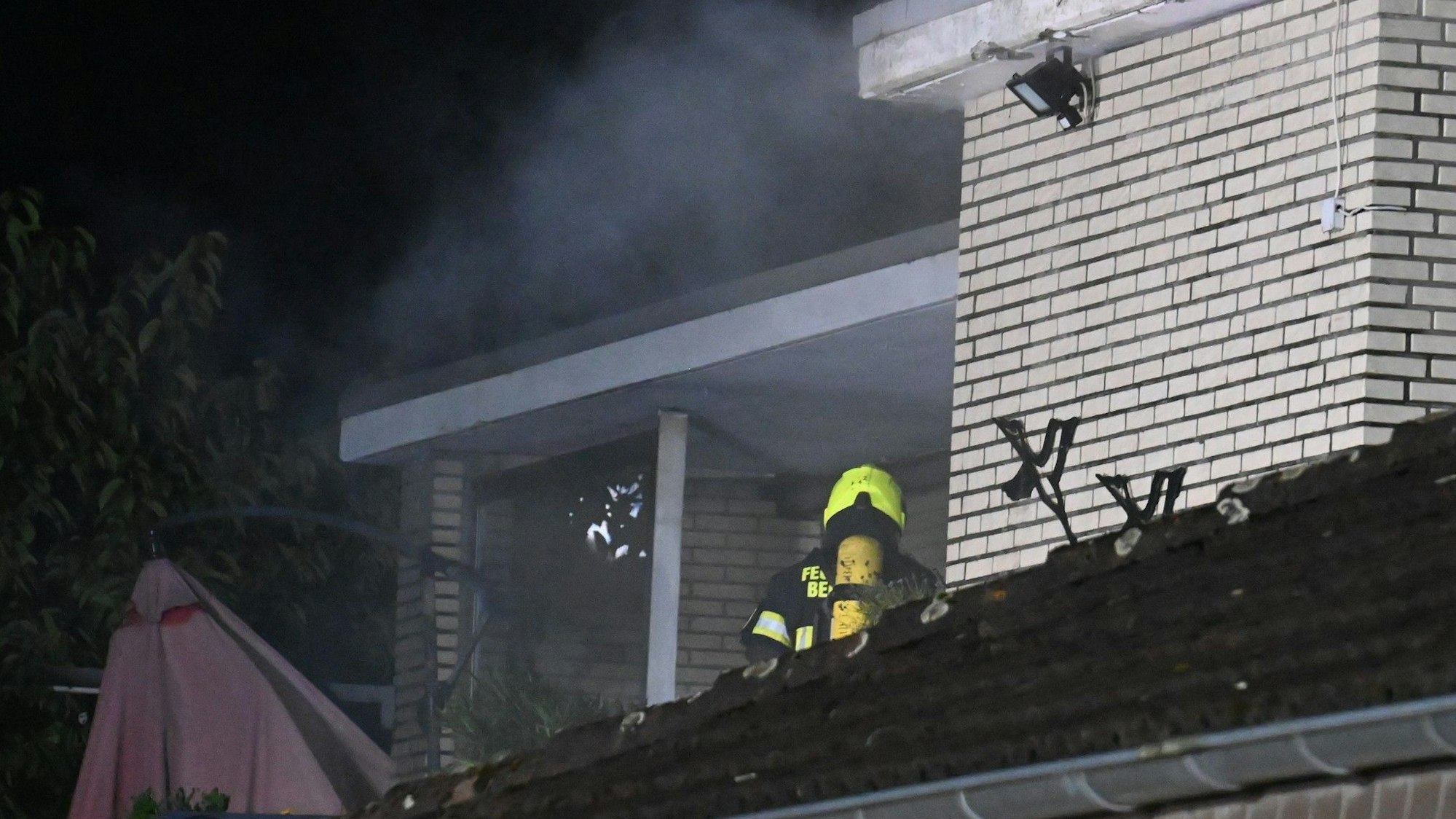 Das Bild zeigt einen Teil einer Dachgeschosswohnung mit einem Feuerwehrmann.