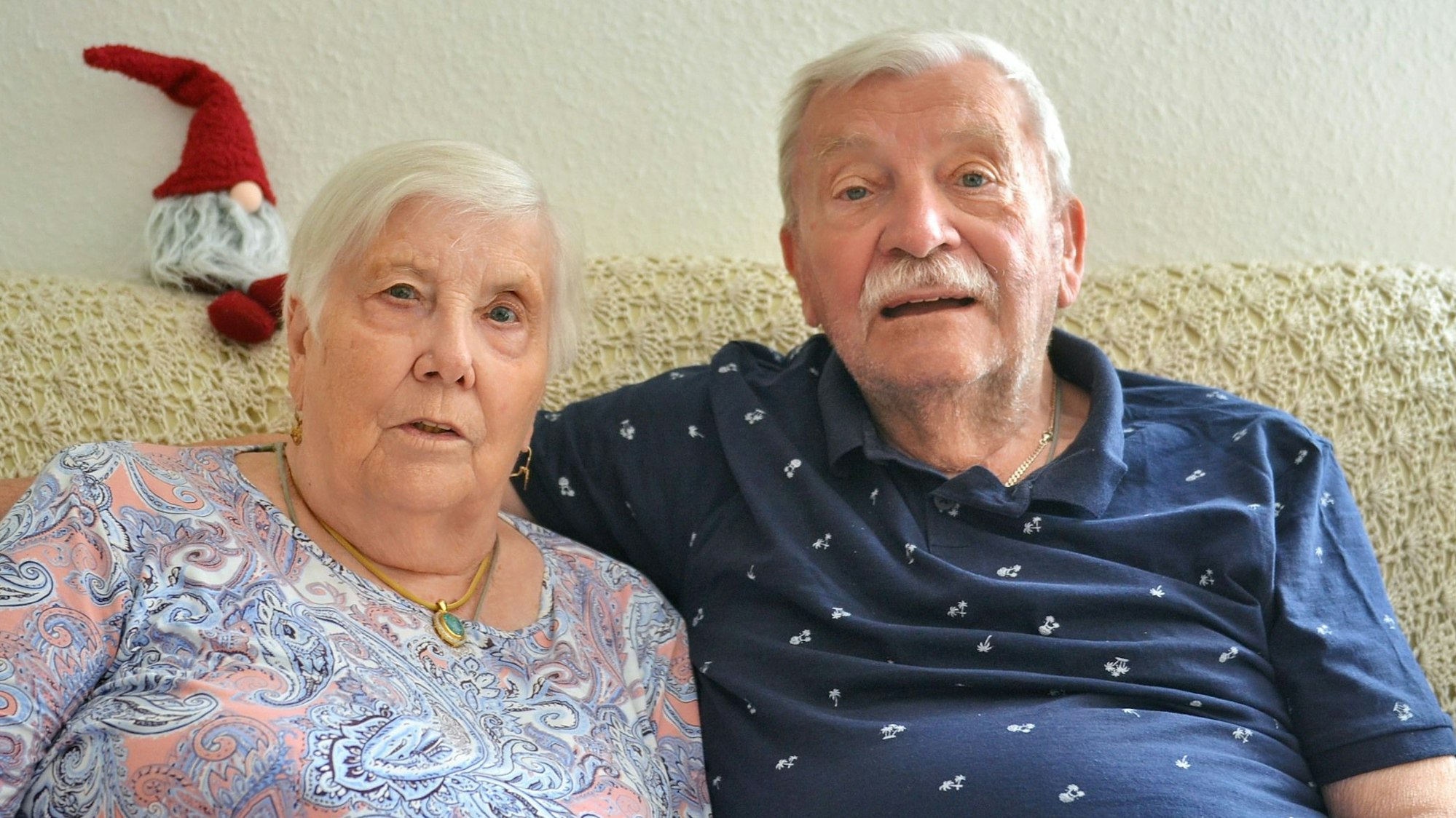 Die Eheleute Christine und Hans Schirk sitzen gemeinsam auf einem Sofa.