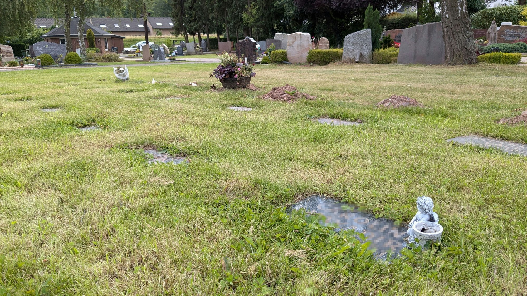 Auf der Grabplatte einer Reihengrabstätte auf dem Friedhof in Strempt steht eine Engelfigur.