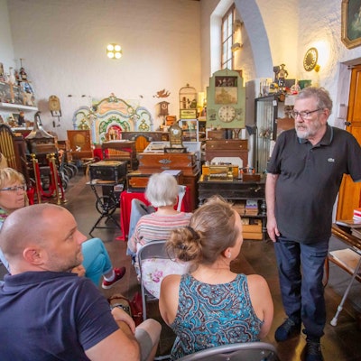 Das Foto im Drehorgelmuseum zeigt Museumsleiter Ullrich Wipper und mehrere Zuhörer.