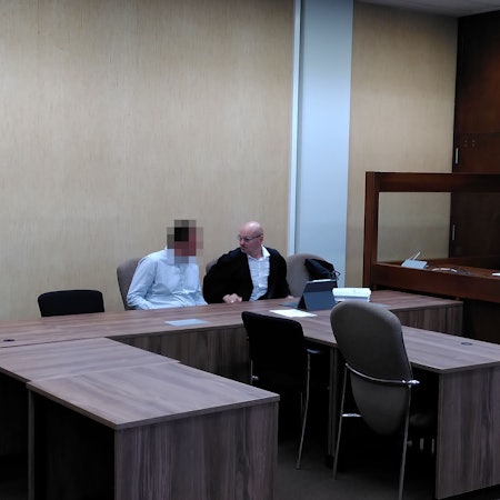 Auf dem Bild ist der Angeklagte mit verpixeltem Gesicht neben seinem Verteidiger im Gerichtssaal zu sehen.