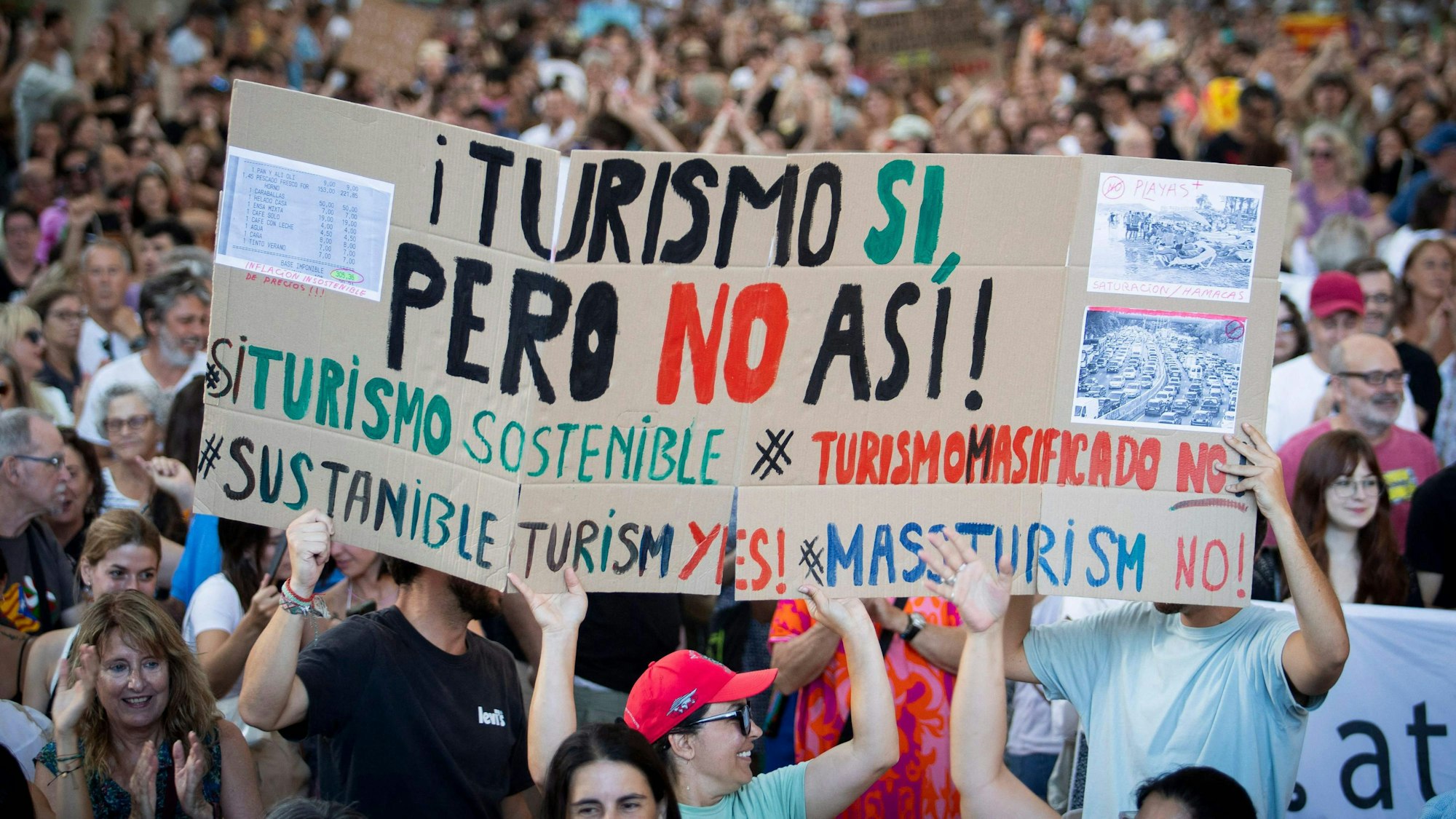 Menschen halten ein Plakat mit der Aufschrift „Tourismus ja, aber nicht so“ während einer Demonstration gegen den Übertourismus und die Immobilienpreise auf der Insel Mallorca in Palma de Mallorca am 21. Juli 2024.