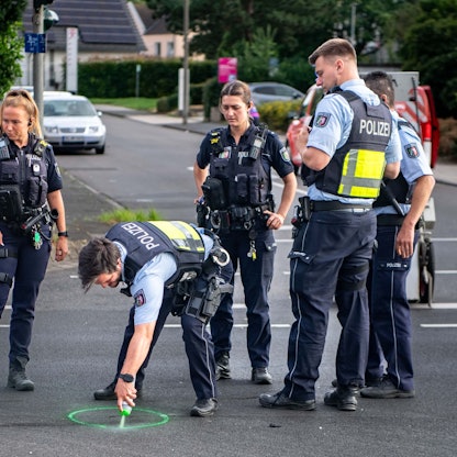 Das Bild zeigt Polizeibeamte an einer Unfallstelle, die Spuren sichern.