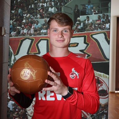 Jonas Urbig, Torhüter des 1. FC Köln, präsentiert im Trainingslager in Bad Waltersdorf einen goldenen Ball.