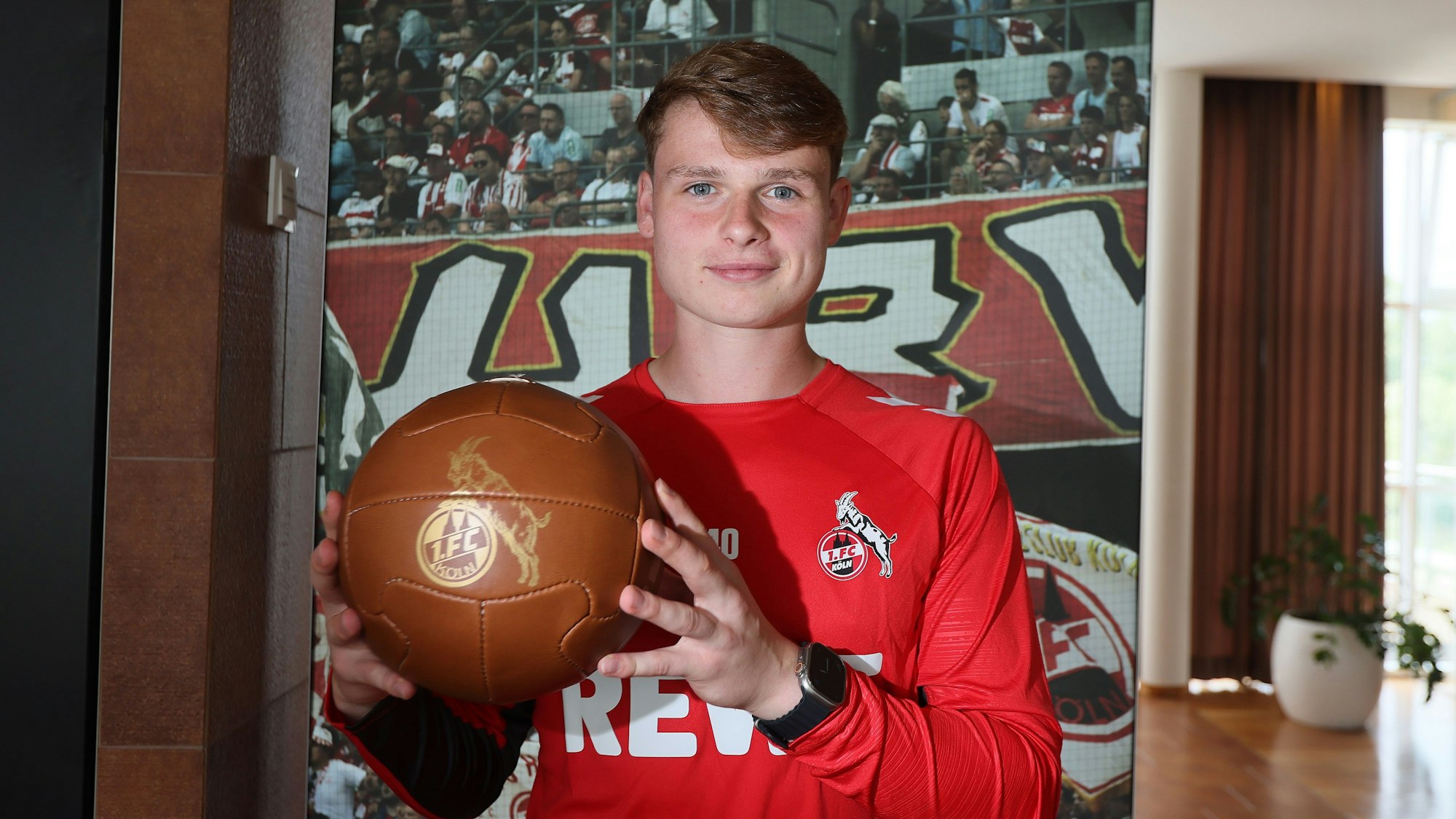 Jonas Urbig, Torhüter des 1. FC Köln, präsentiert im Trainingslager in Bad Waltersdorf einen goldenen Ball.