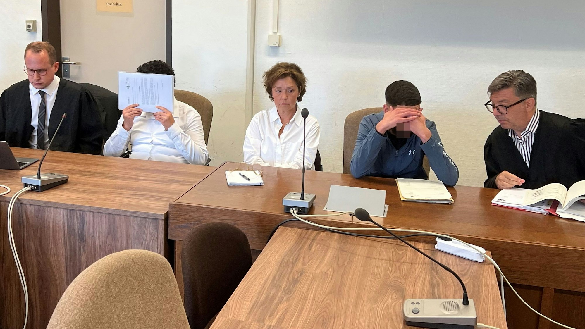 Die Angeklagten mit ihren Verteidigern und einer Dolmetscherin beim Prozessauftakt im Landgericht Köln