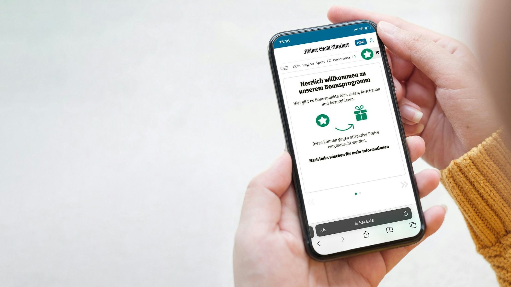 Eine Person hält ein Smartphone in der Hand, auf der man das Bonusprogramm auf ksta.de entdecken kann.