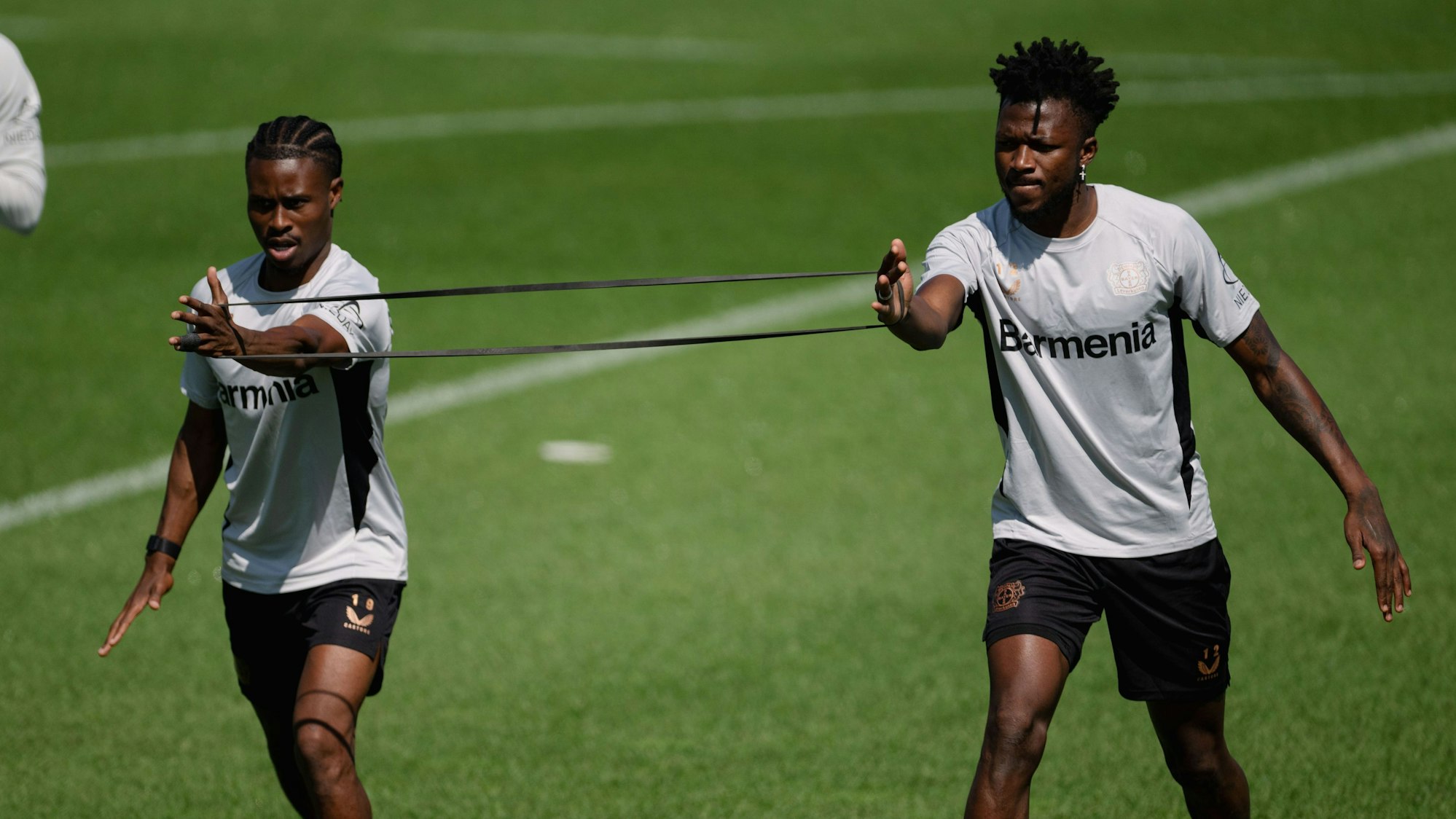 Vorbereitung bei Bayer 04 Leverkusen. Nathan Tella (l) und Edmond Tapsoba trainieren mit der Mannschaft.