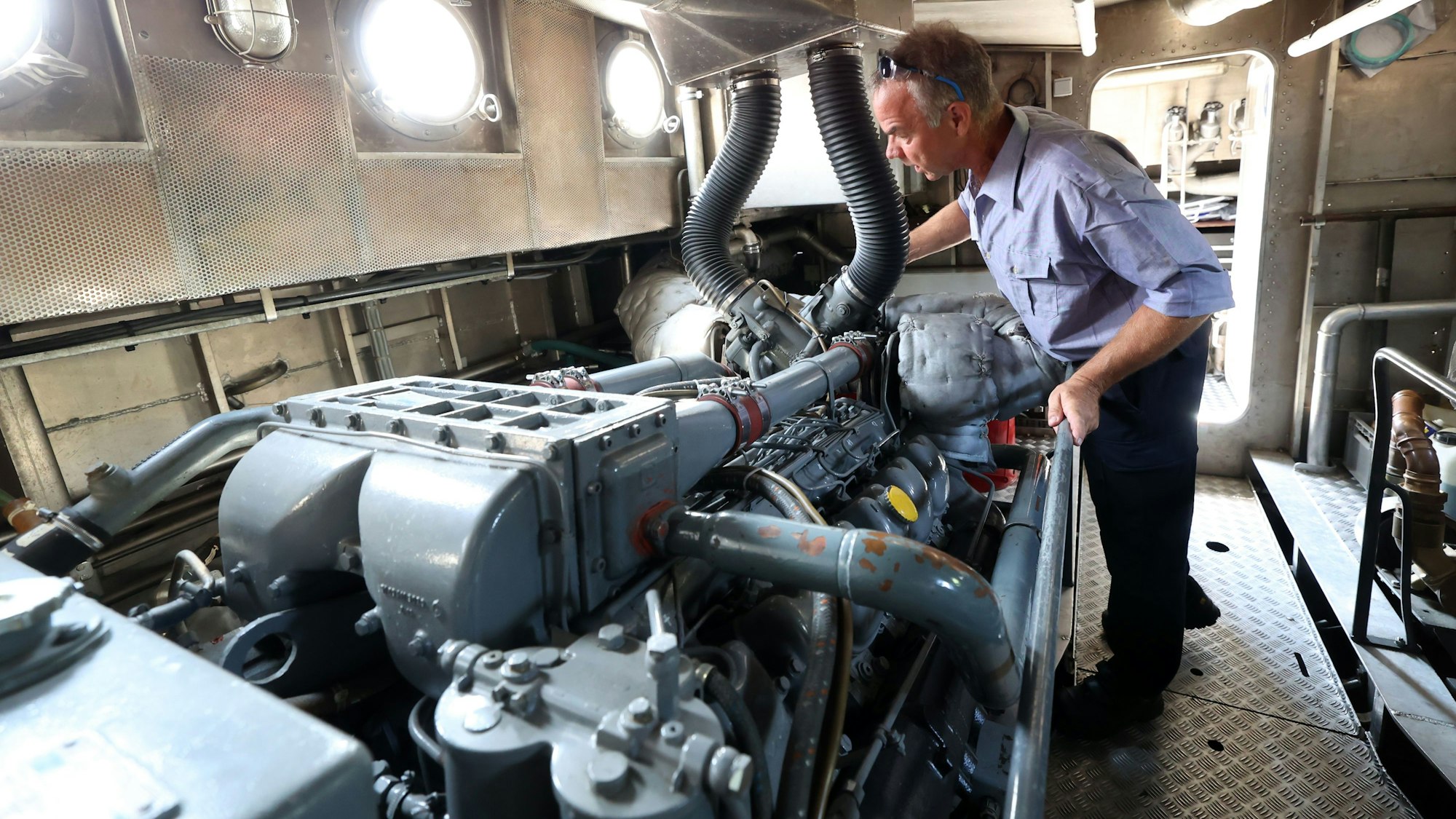 Bootsmaschinist und Feuerwehrmann Stefan Tietze prüft den Motor der „Branddirektor Hans“.