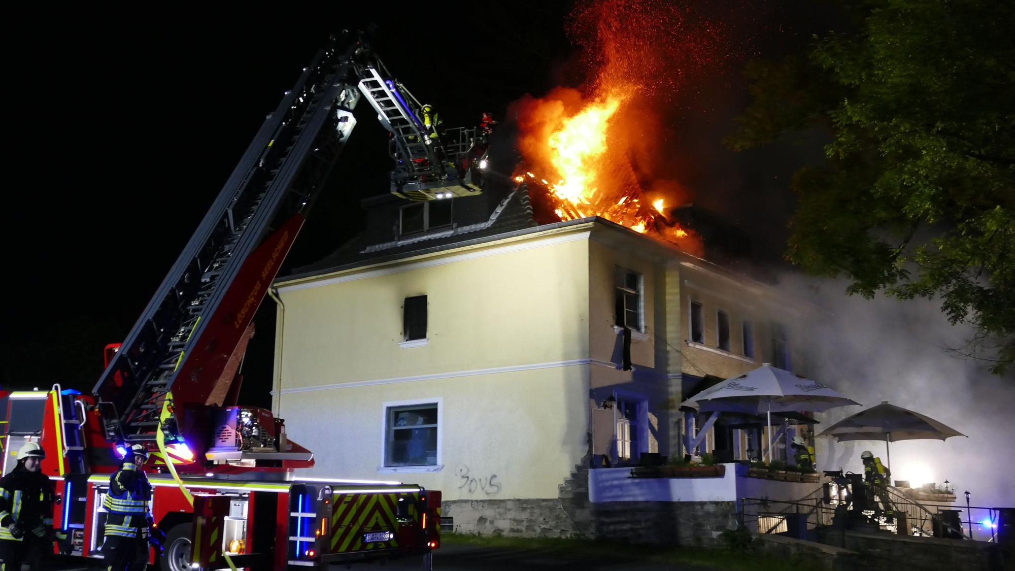 Die Drehleiter vor dem brennenden Gebäude.