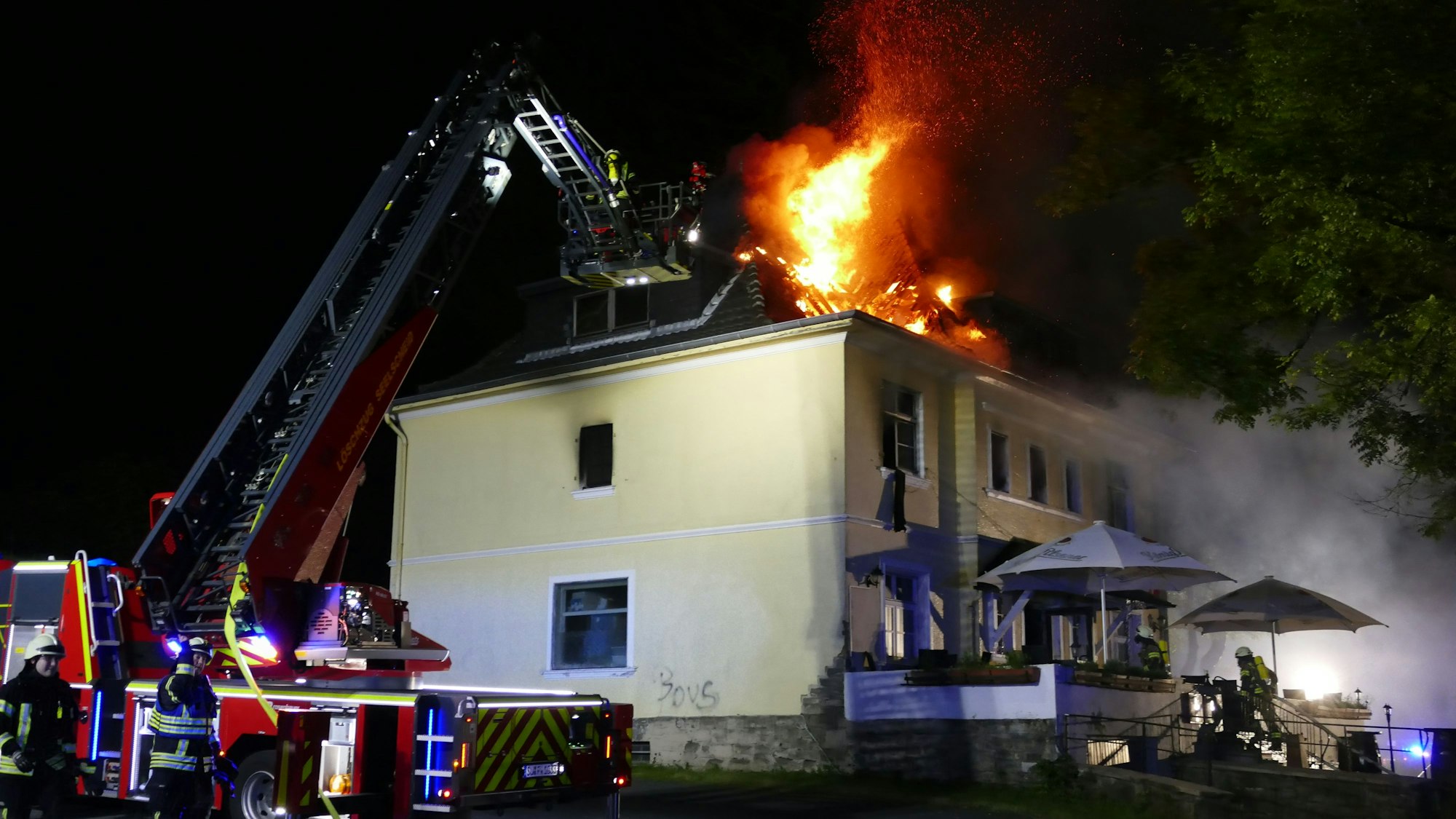 Die Drehleiter vor dem brennenden Gebäude.