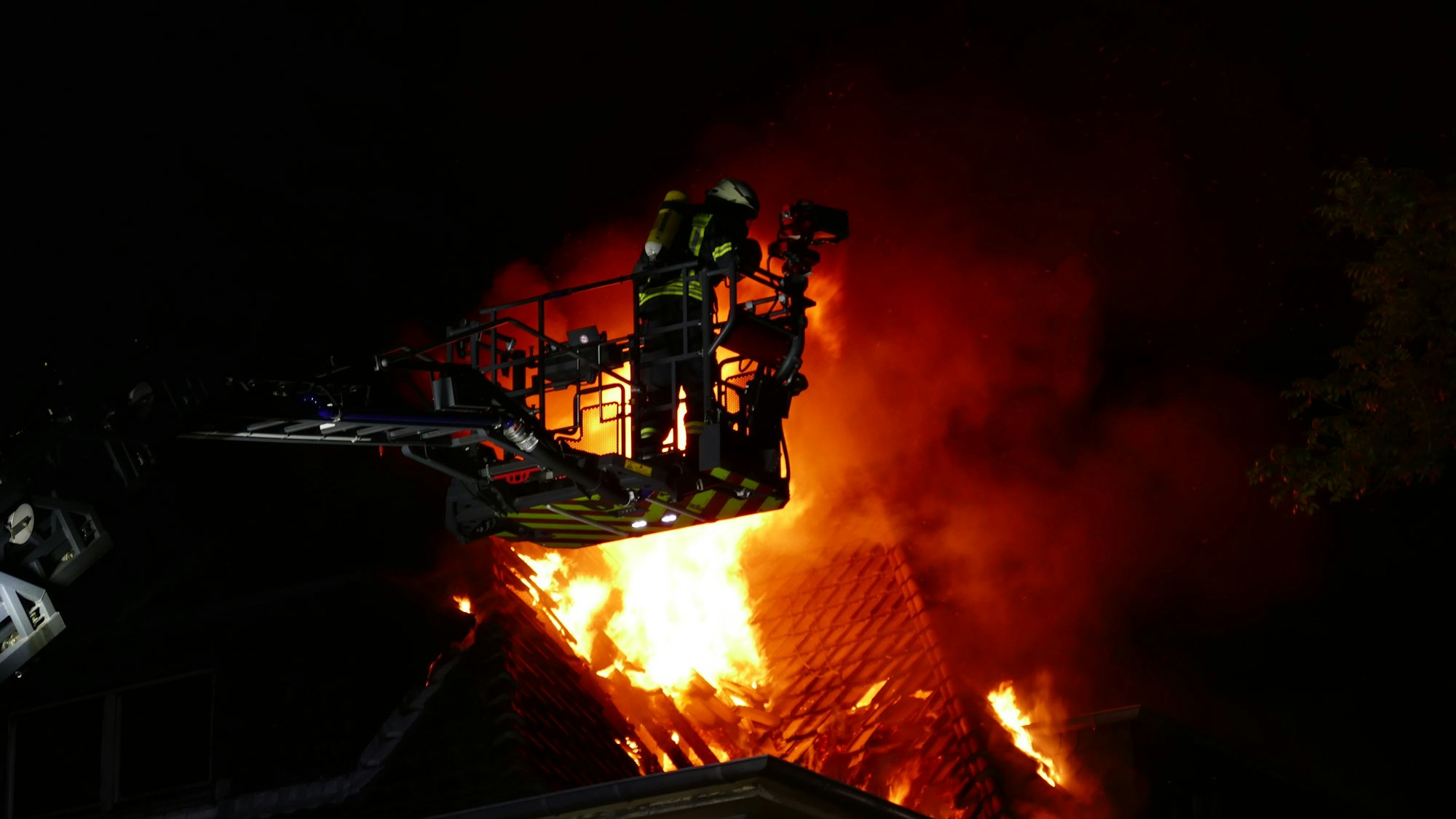 Feuerwehrleute auf einer Leiter und an einem Fenster.