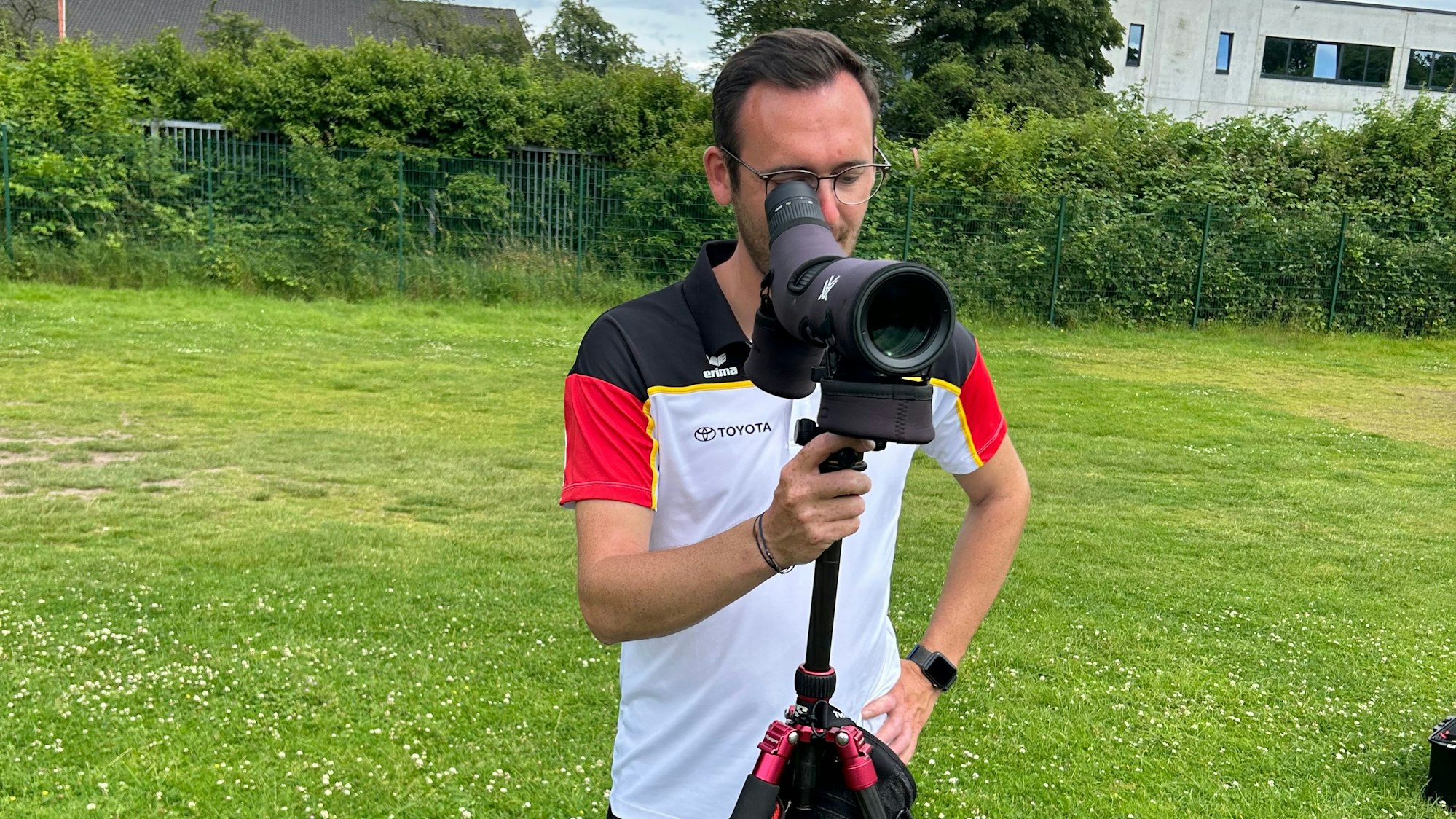 Trainer Freddy Siebert blickt durch ein Spektiv auf die Zielscheibe