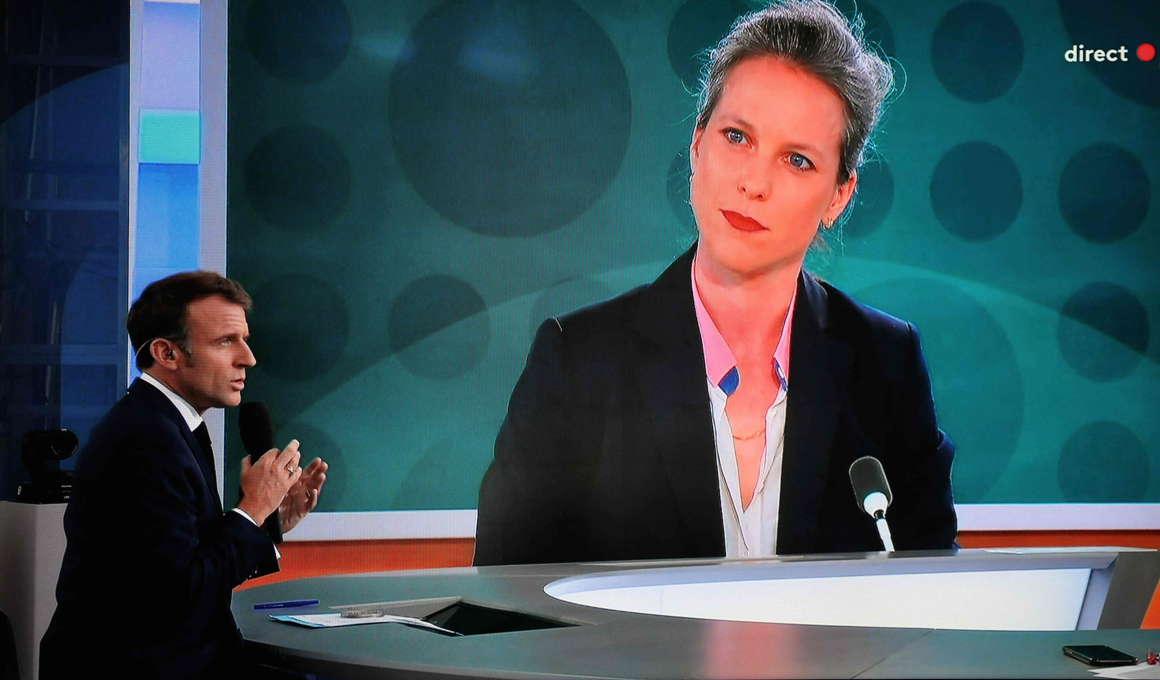 Dieses Foto zeigt einen Fernsehbildschirm, auf dem Frankreichs Präsident Emmanuel Macron ein Live-Interview gibt, während ein Porträt von Lucie Castets, der Kandidatin der "Nouveau Front Populaire" für das Amt des Premierministers, auf einem riesigen Bildschirm des französischen Fernsehsenders France 2 zu sehen ist.