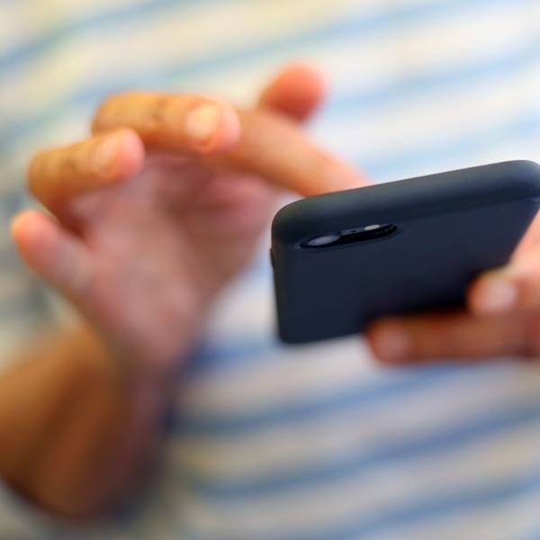 Eine Frau tippt auf einem Smartphone.