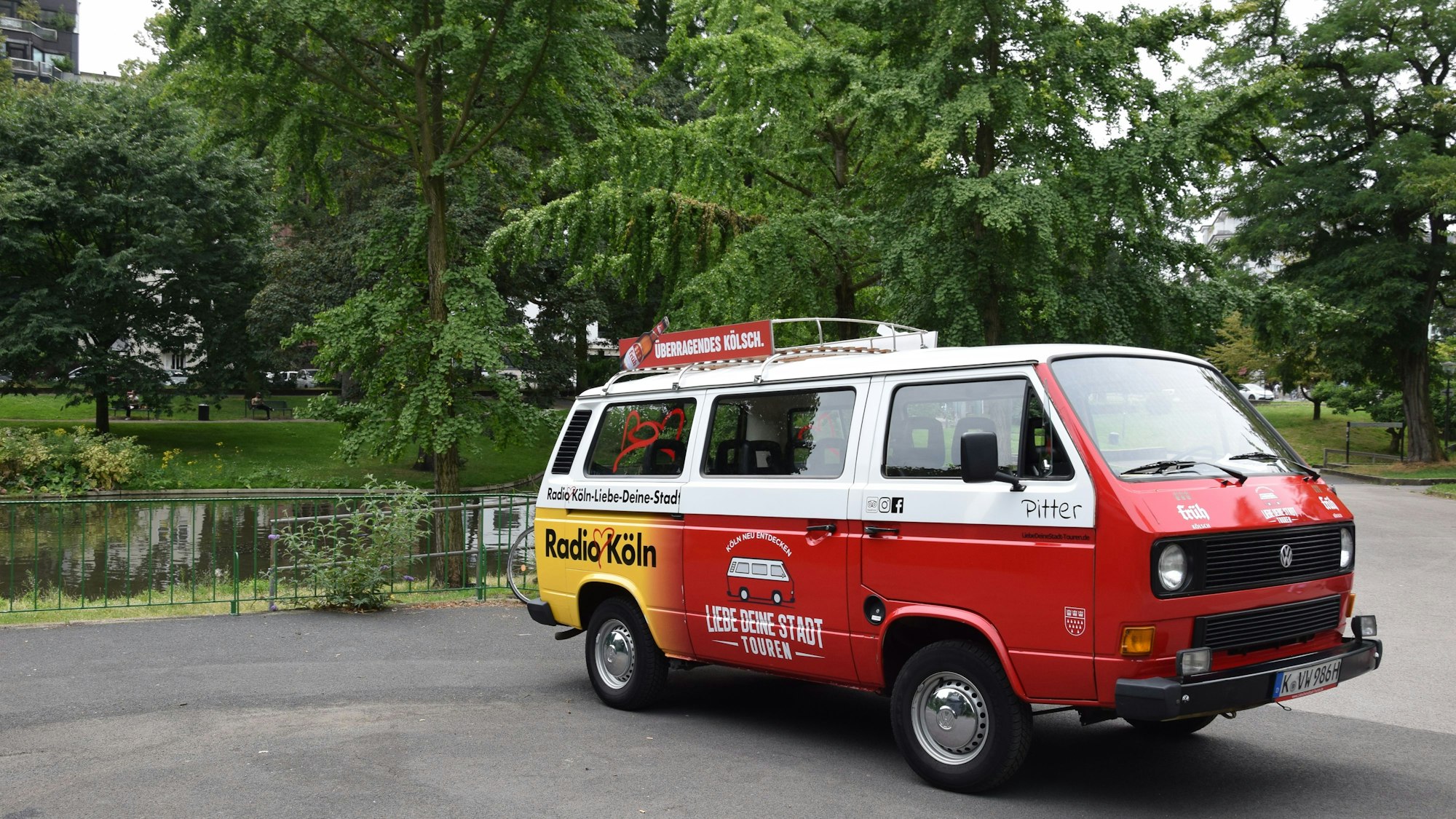 Ein rot-weißer Bulli steht am Ebertplatz/Theodor-Heuss-Weiher.
