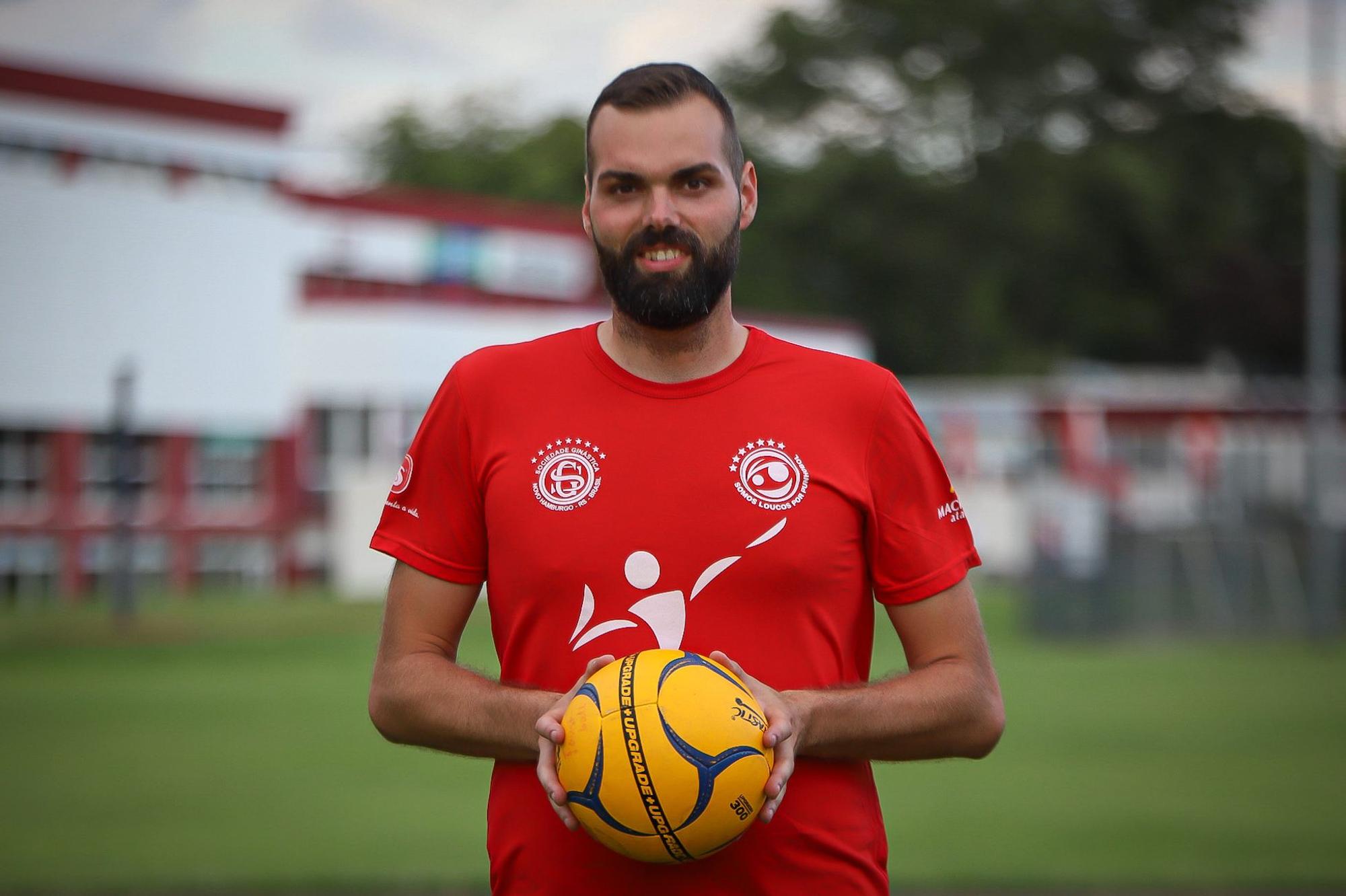 Niklas Hodel hällt einen Faustball in der Hand und guckt in die Kamera.