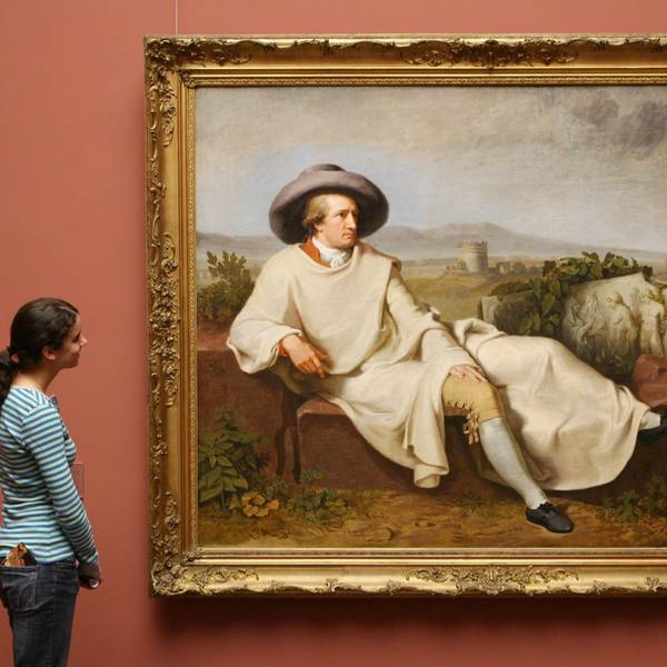 Eine Frau steht vor einem Bildnis von Goethe.