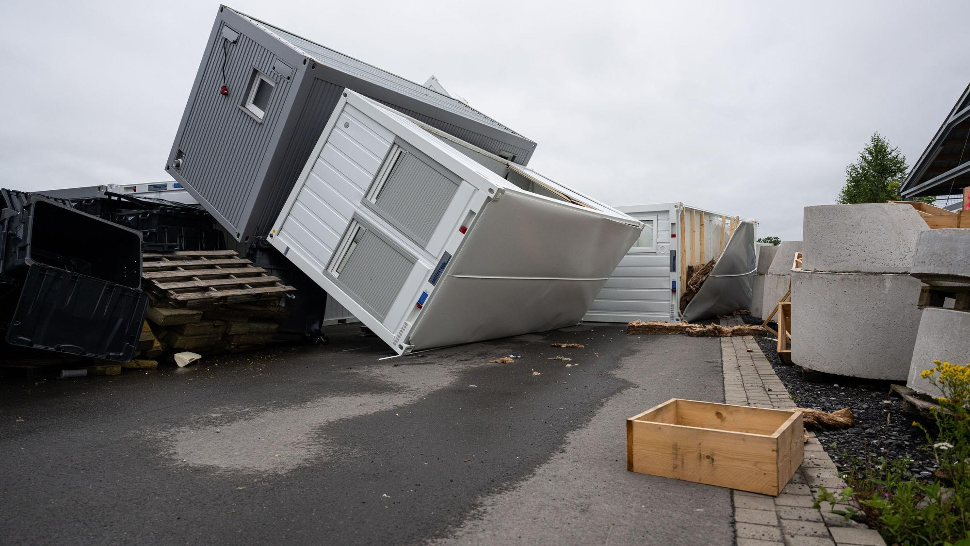 Umgestürzte Container, Bauteile und Trümmer liegen nach einem Sturm auf einem Hof einer Firma in Telgte.