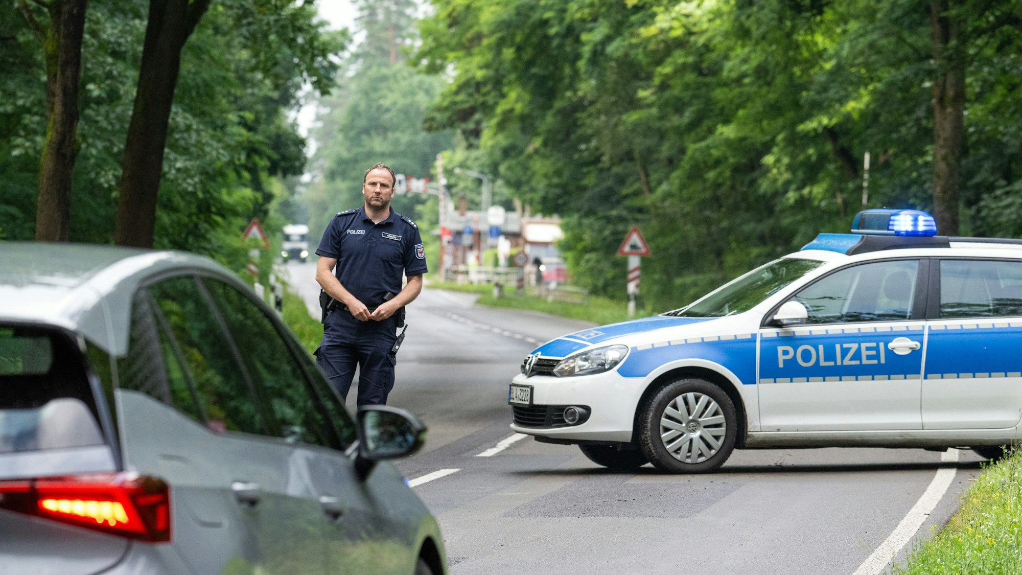 24.07.2024, Brandenburg, Grünheide: Ein Fahrzeug muss kurz vor Beginn des Sperrkreises am Bahnhof Fangschleuse unweit der Tesla Gigafactory auf der Landstraße L23 wenden.