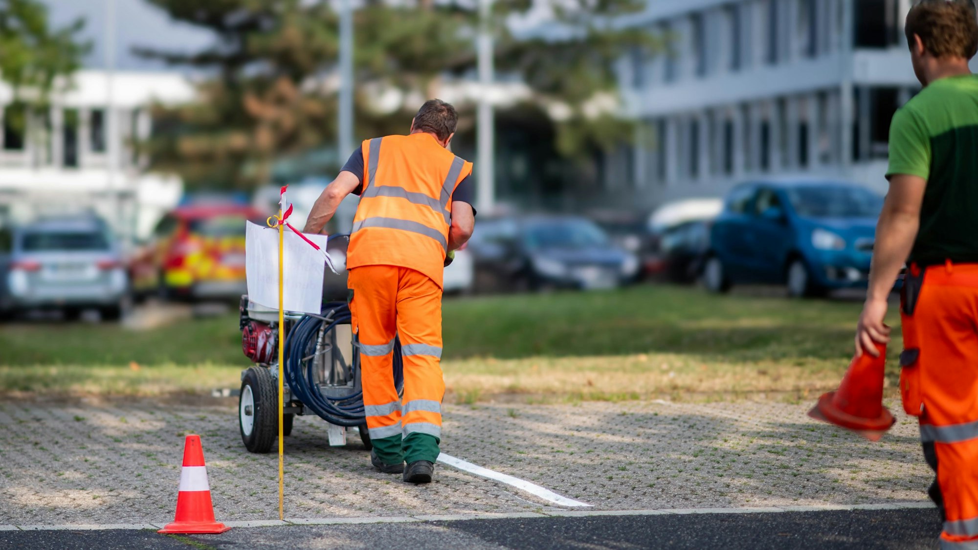 Das Bild zeigt Mitarbeiter des Kreisbauhofs, die Parkbuchten markieren.