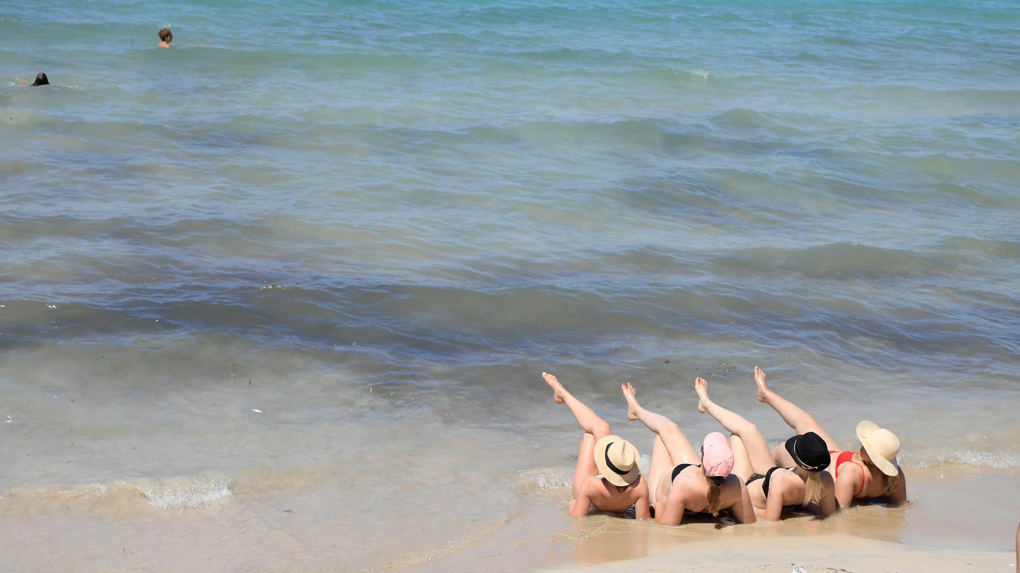 Touristen genießen den Sommertag am Strand von Arenal.