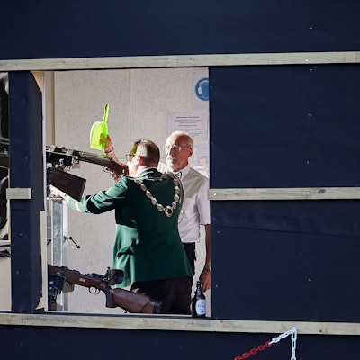 Rainer Schmitz nutzt eine Kehrschaufel, um Markus Müller vor den Strahlen der tiefstehenden Sonne zu schützen.